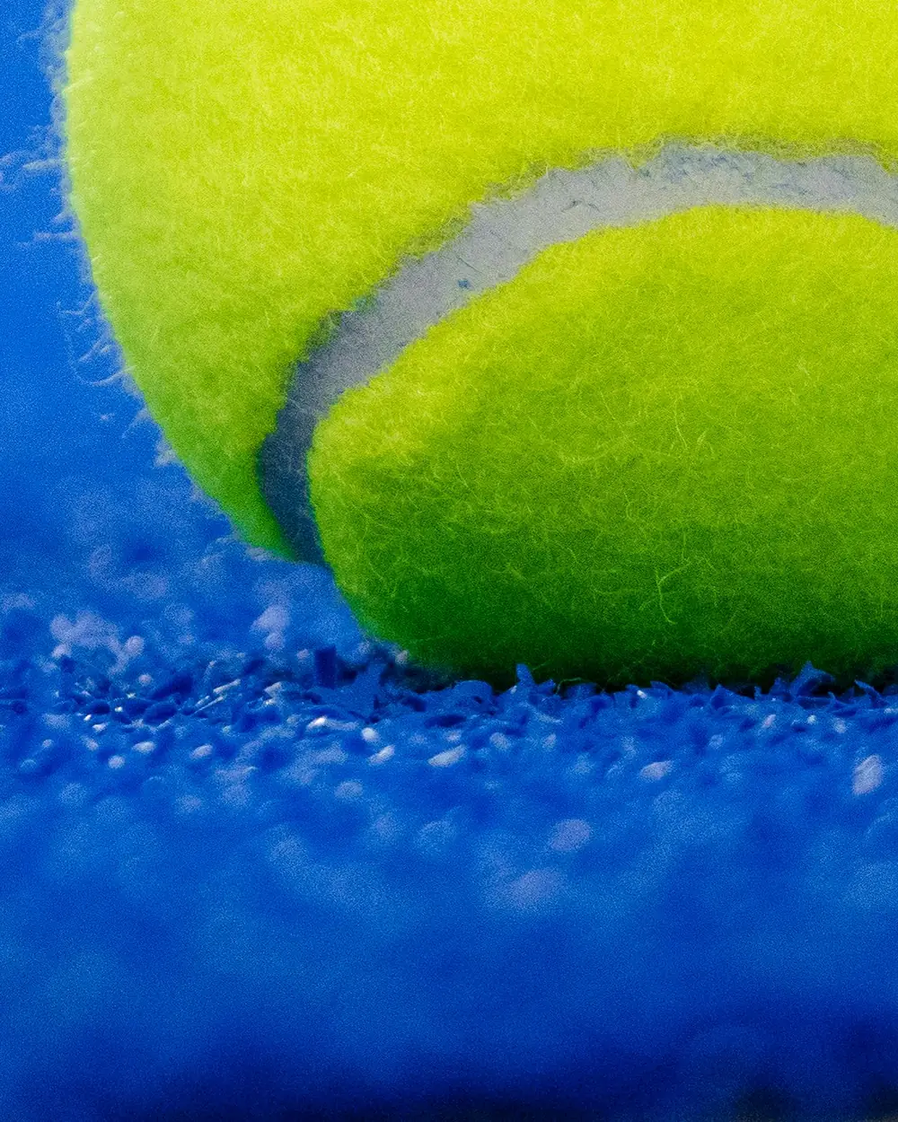 Close-up of a padel ball on blue court turf