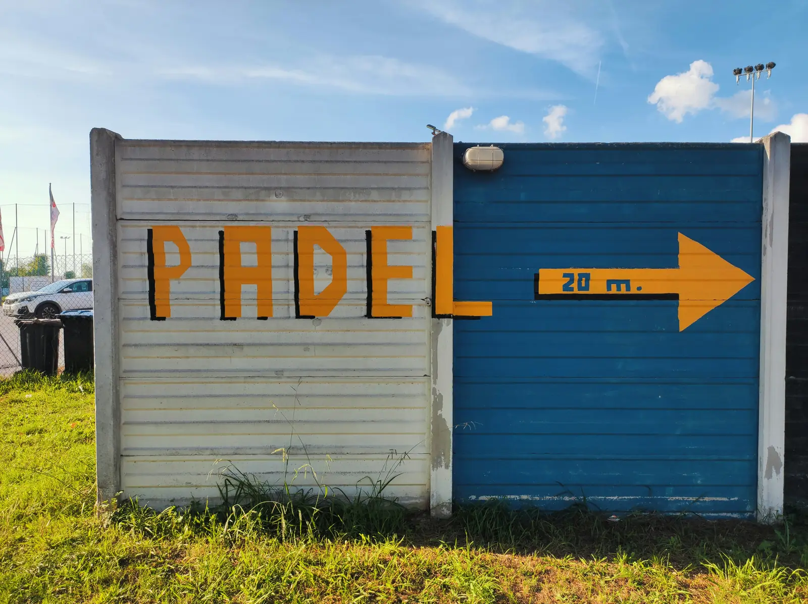 A painted wall sign reading Padel with an arrow pointing the way